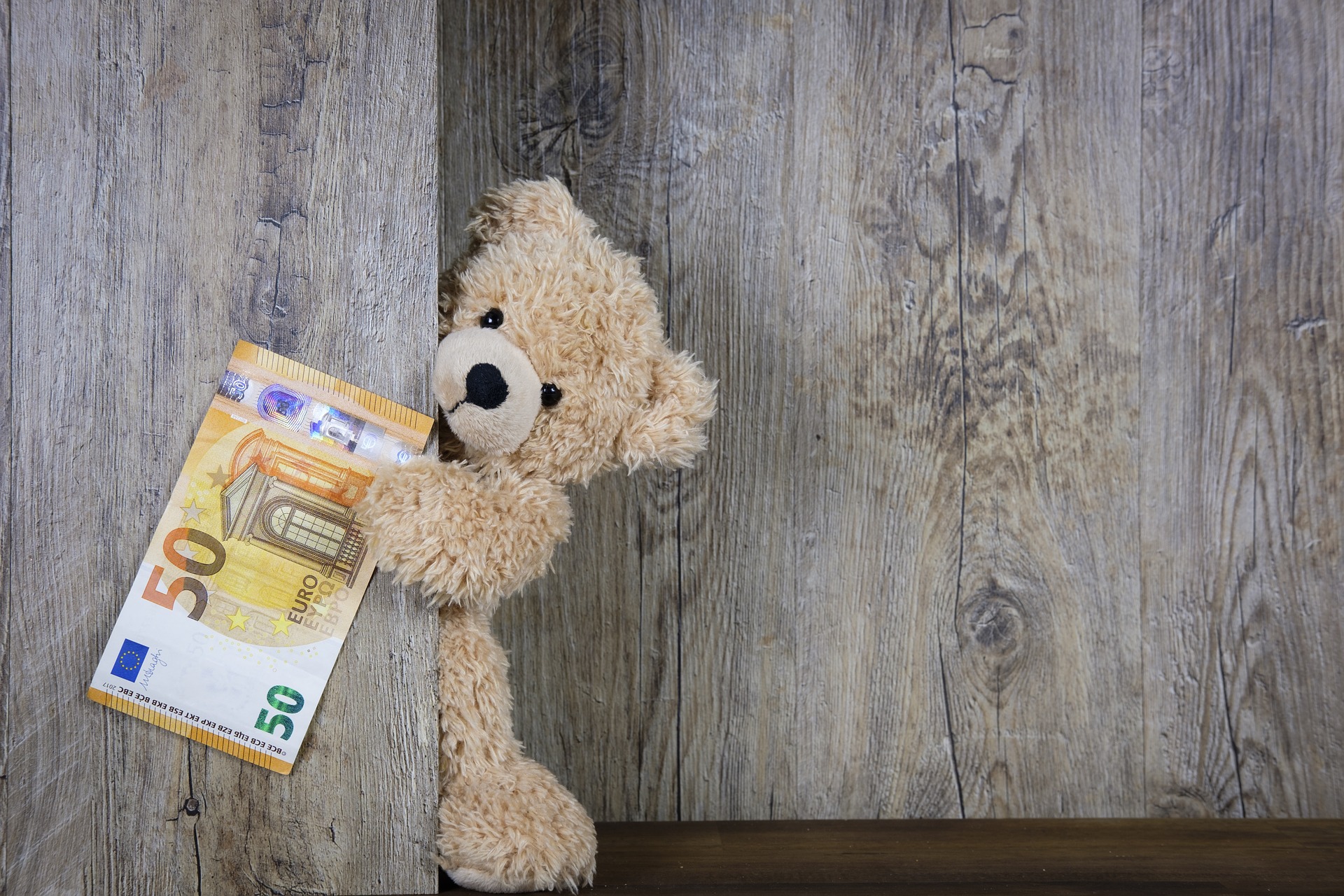 Ein Teddybär hält einen 50-Euro-Gutschein in der Pfote