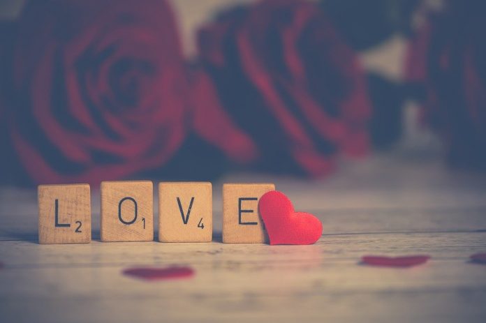 Vier Buchstabenwürfel zeigen das Wort Love
